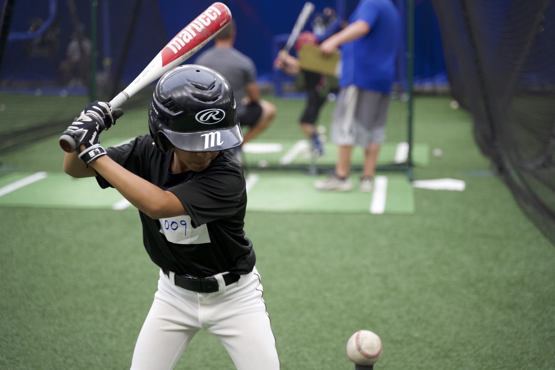 Youth Gameday player taking batting practice swings indoors