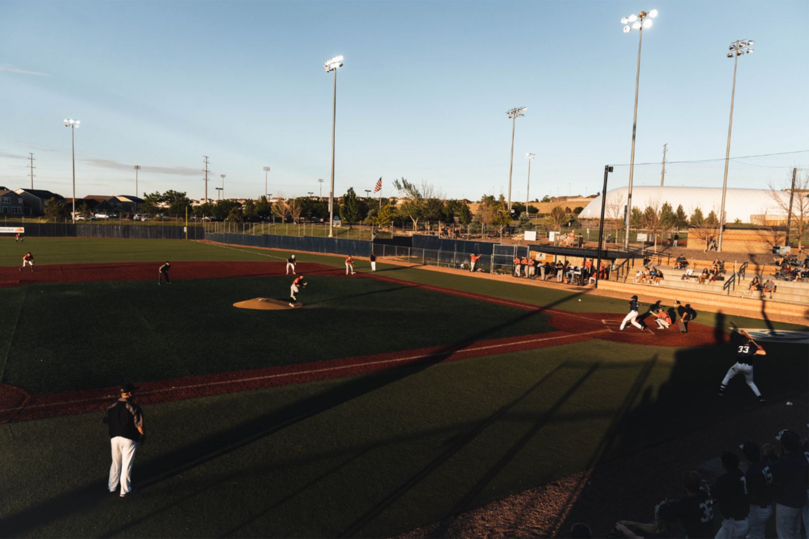 Youth baseball player sliding on field at golden hour